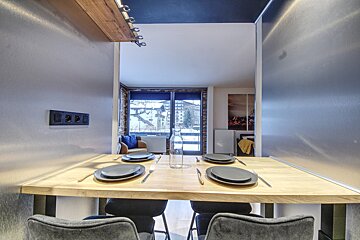A table with plates and silverware and a bottle of water on it