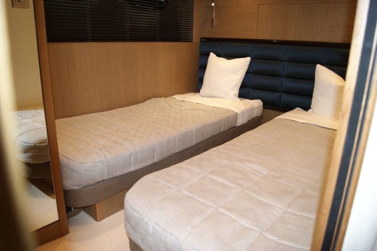 A bedroom with two beds and a mirror