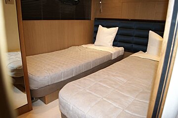 A bedroom with two beds and a mirror