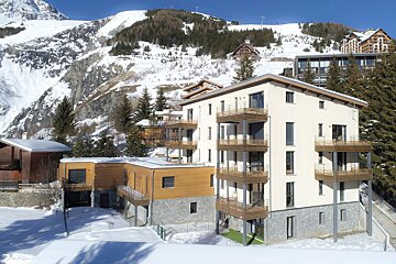 A building with a mountain in the background is covered in snow