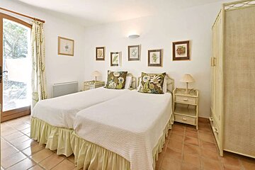A bedroom with two beds and pictures on the wall