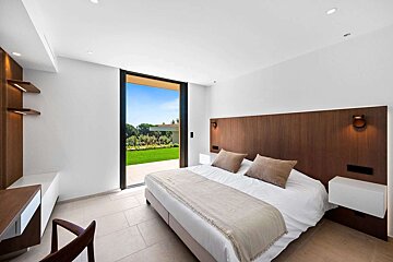 A bedroom with a large bed and a sliding glass door