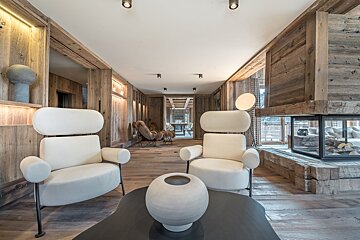 A living room with two chairs and a vase on a table