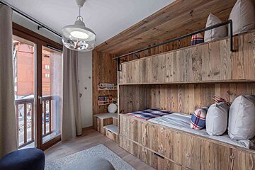A bedroom with a large bed and a balcony