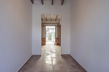 An empty hallway with tile floors and white walls