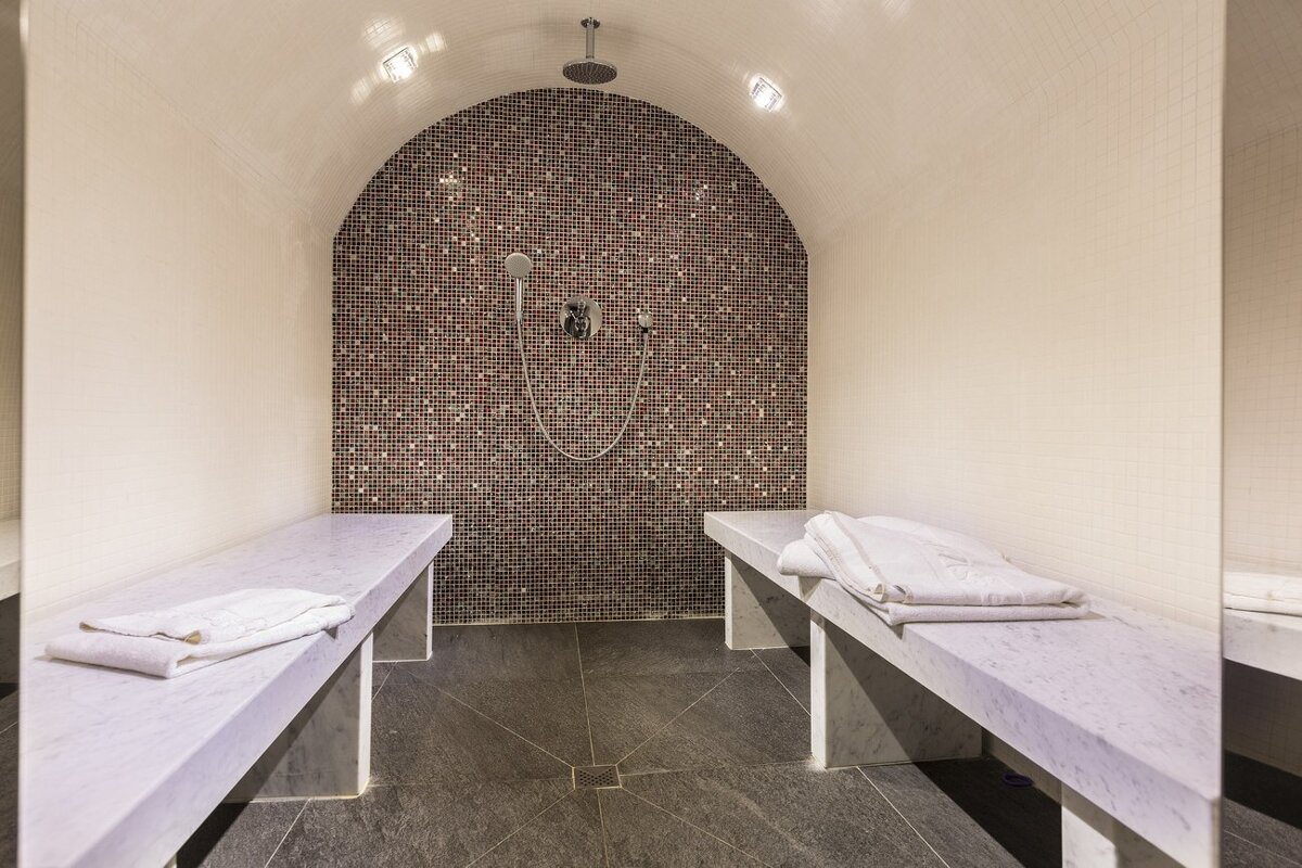 A bathroom with a mosaic wall and a shower