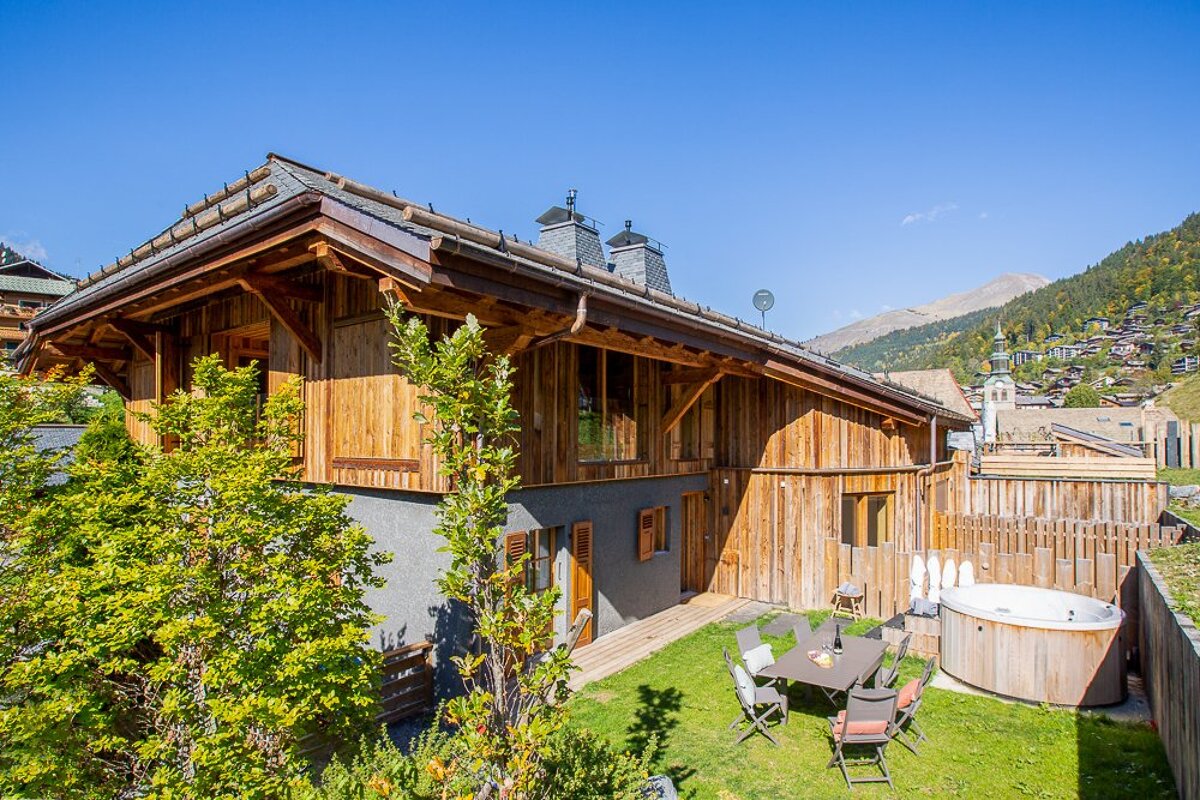 A wooden house with a hot tub in front of it