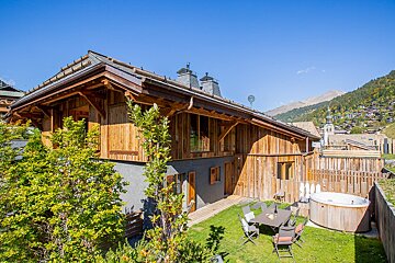 A wooden house with a hot tub in front of it