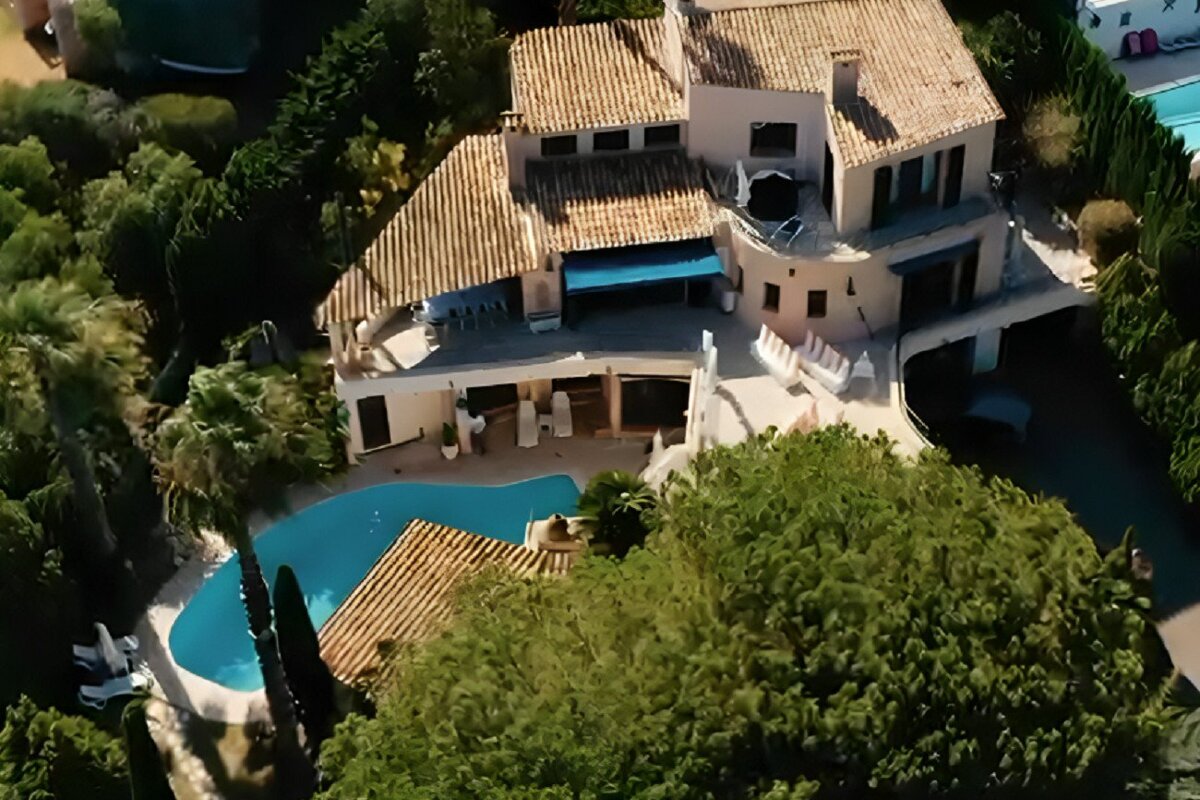 An aerial view of a large house with a large pool