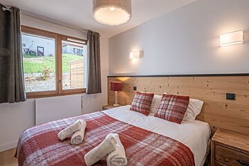 A bedroom with a large bed and a window