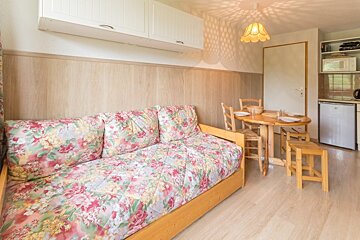 A living room with a floral couch and a table