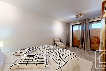 A bedroom with a bed a chair and a sign that says alpine property
