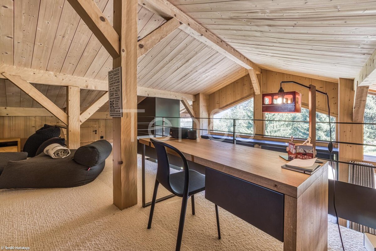 A room with a wooden table and chairs and a sign on the wall that says ' a ' on it