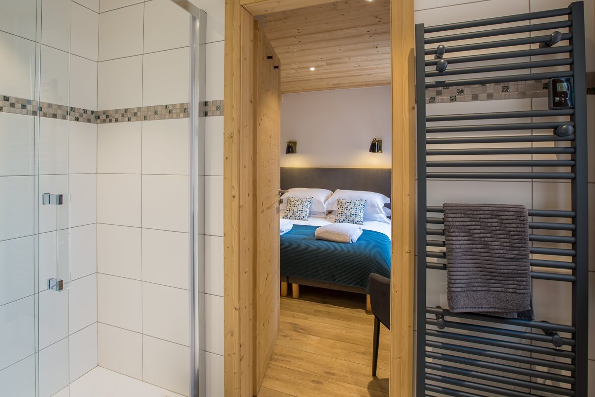 A bedroom with a bed and a towel rack
