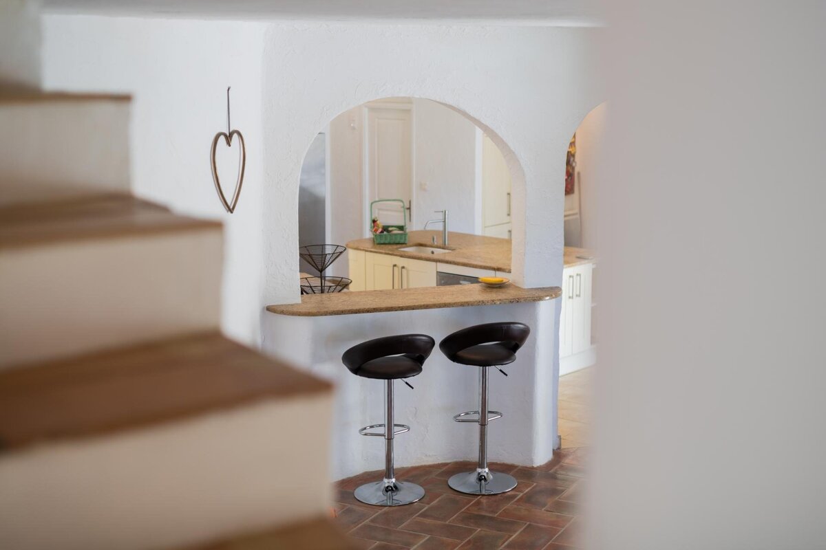 A kitchen with two bar stools and a heart on the wall