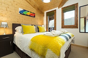 A bedroom with a painting of cars on the wall above the bed