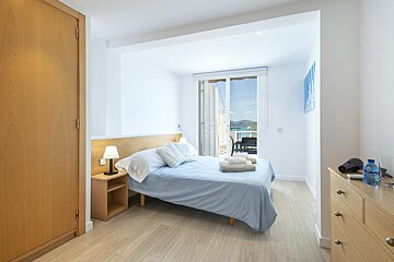 A bedroom with a bed and a bottle of aquafina water