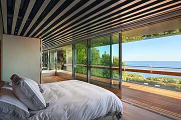 A bedroom with a bed and a view of the ocean