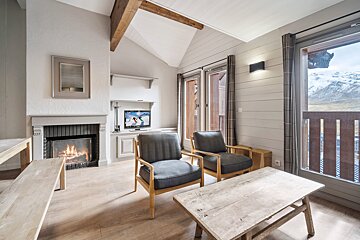A living room with two chairs and a fireplace