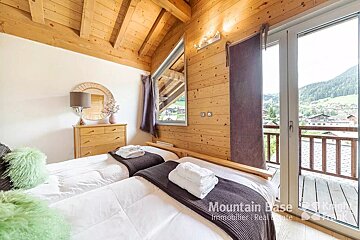 A bedroom with two beds and the word mountain base on the bottom