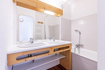 A bathroom with two sinks and a bathtub