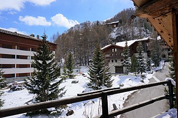 A view of snow covered trees and buildings from a balcony