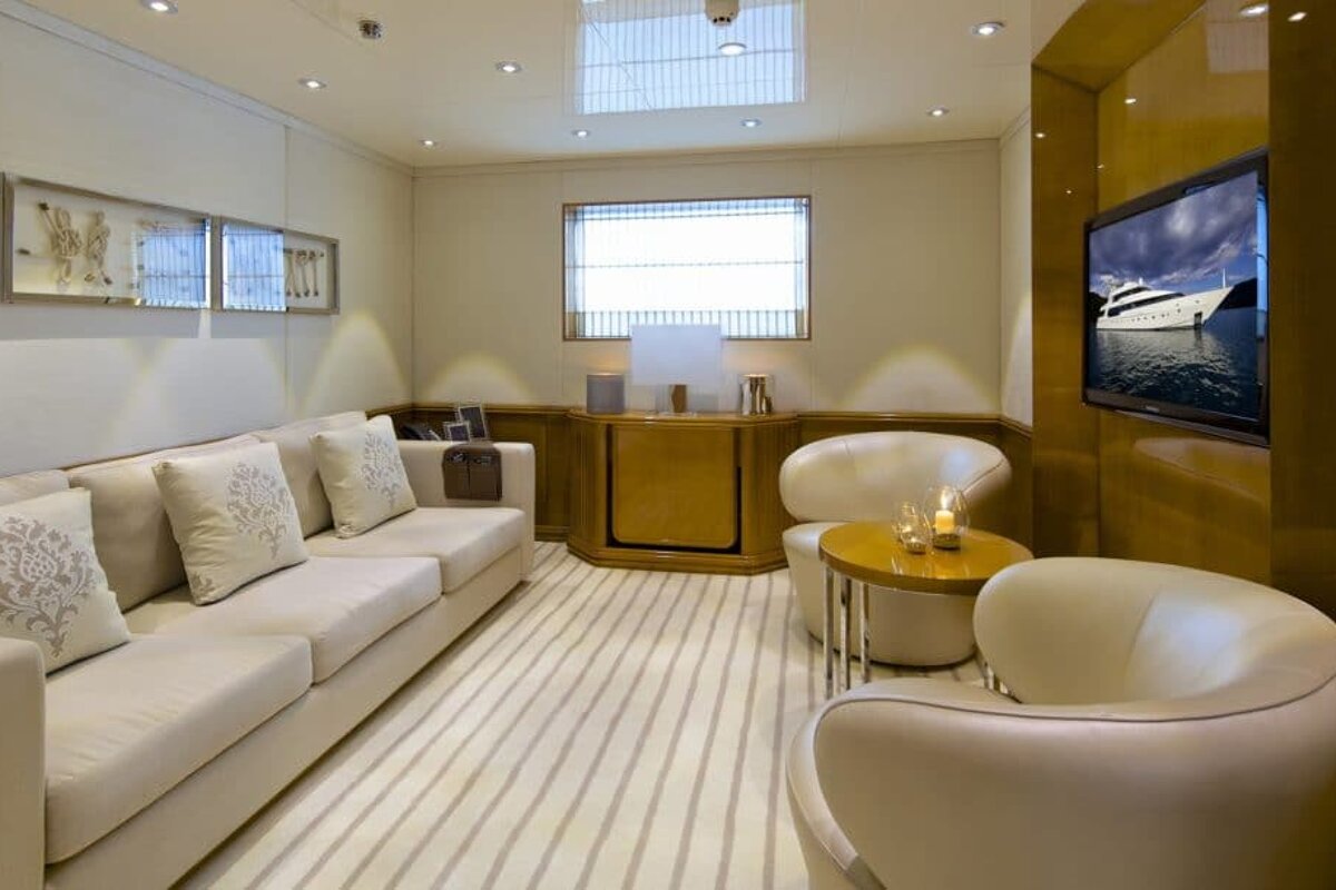 A living room with a couch and chairs and a television with a boat on it