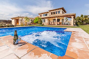 A bottle of champagne sits on the edge of a swimming pool