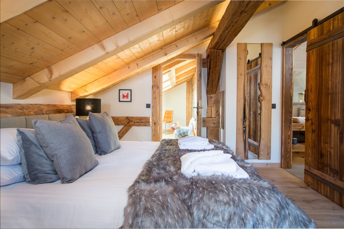 A bedroom with a sliding barn door leading to a bathroom