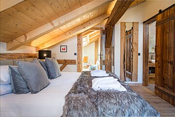 A bedroom with a sliding barn door leading to a bathroom