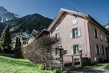 A pink house with a mountain in the background