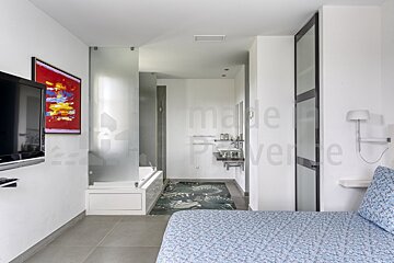 A bedroom with a painting on the wall that says made in provence