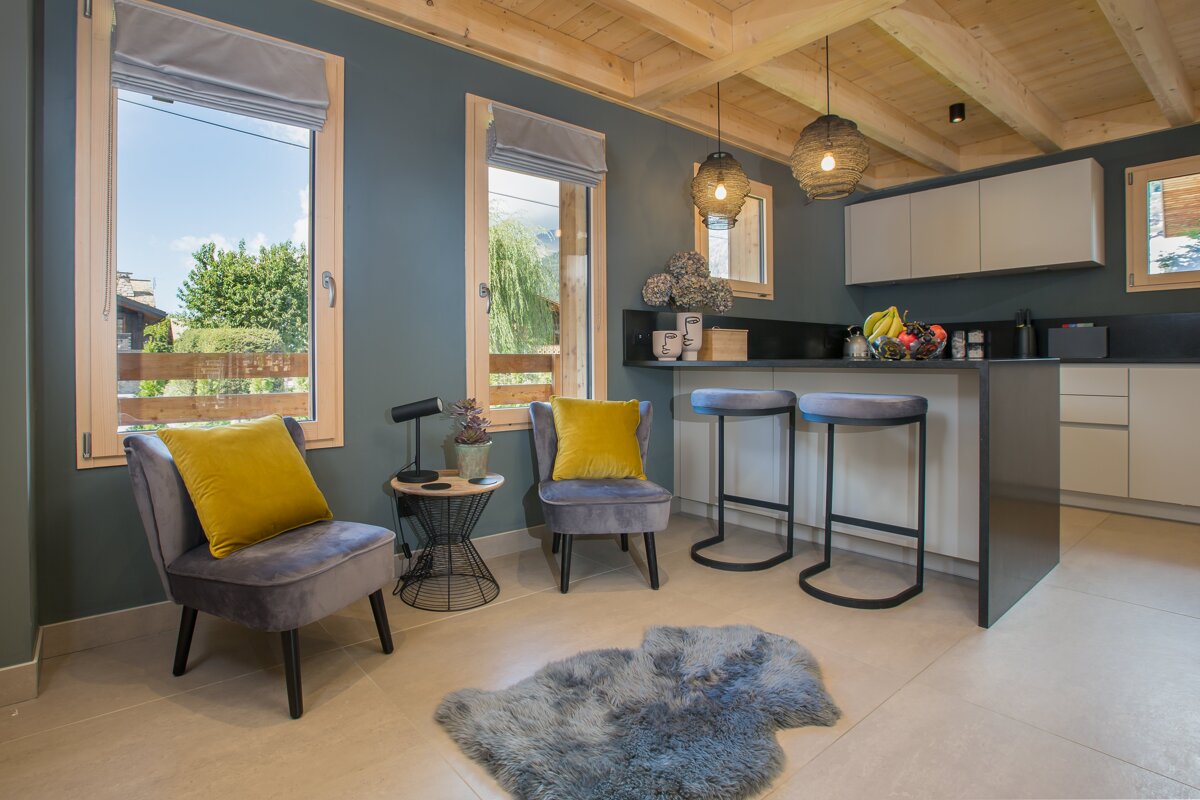 A kitchen with two chairs and a rug on the floor