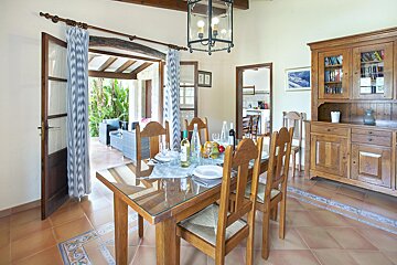 A dining room table with a bottle of wine on it