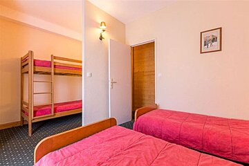 A bedroom with bunk beds and two twin beds