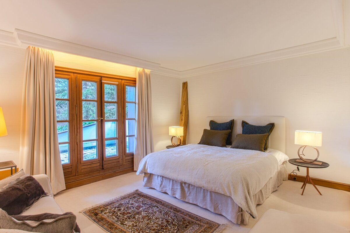A bedroom with a large bed and two lamps