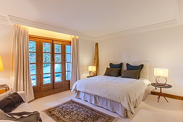 A bedroom with a large bed and two lamps