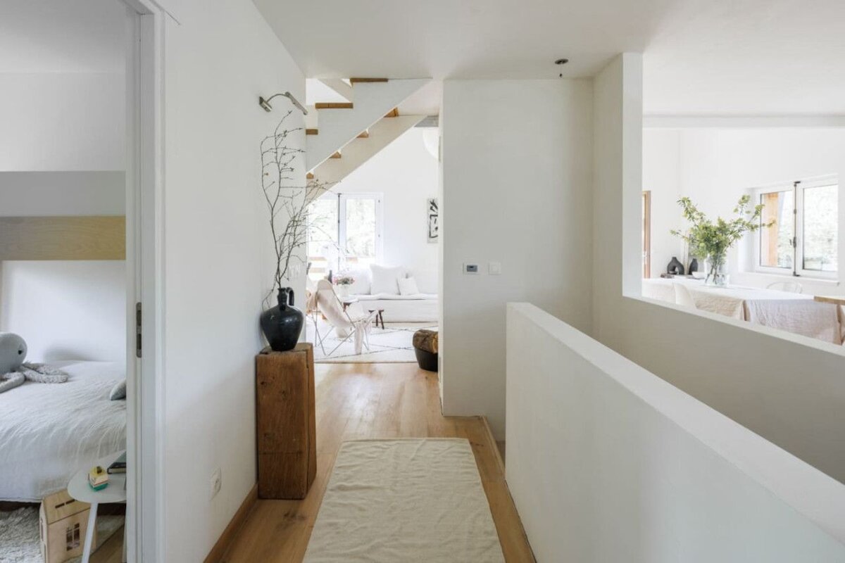 A white hallway leading to a living room and bedroom