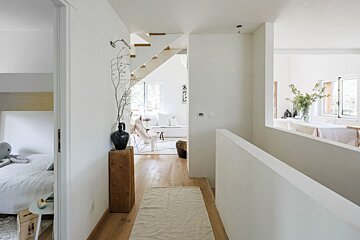 A white hallway leading to a living room and bedroom