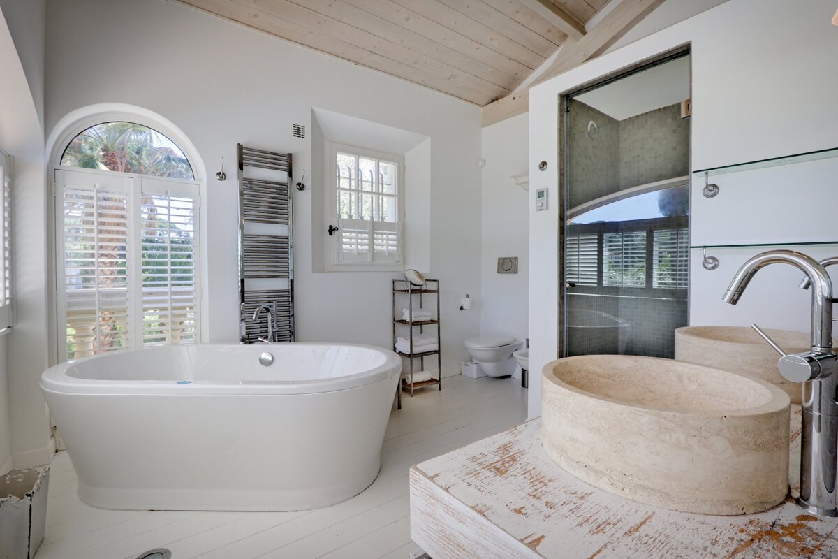 A bathroom with a bathtub and two sinks