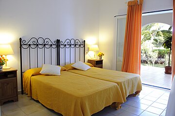 A bedroom with two beds and a sliding glass door
