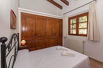 A bedroom with a bed a lamp and a window