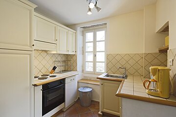 A kitchen with white cabinets and a yellow coffee maker