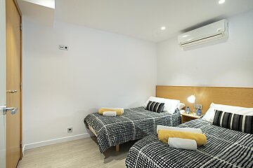 A bedroom with two beds and an air conditioner