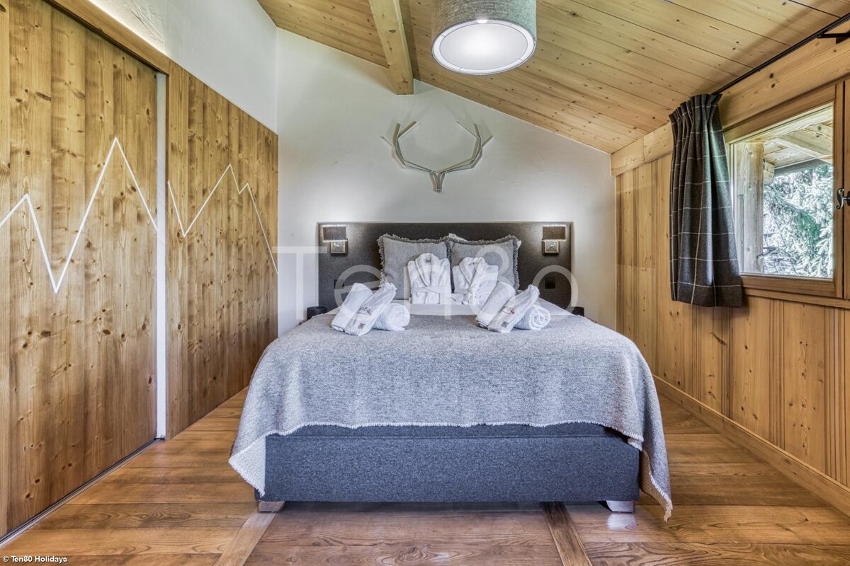 A bedroom with a bed and antlers on the wall