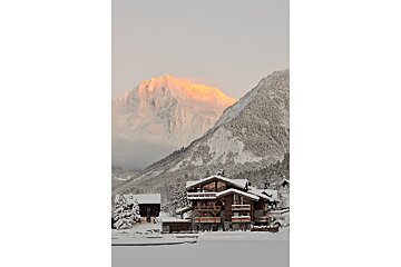 A snowy mountain with a house in the foreground