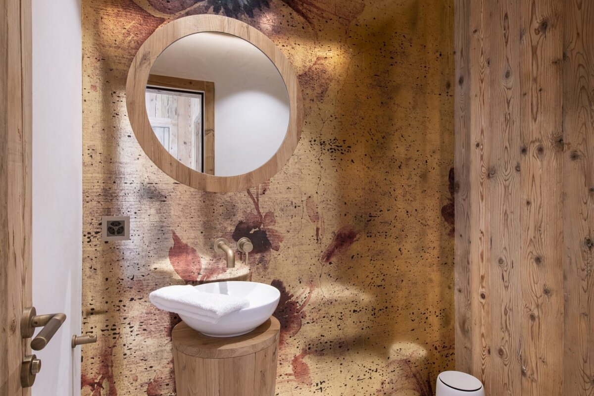 A bathroom with a round mirror and a sink