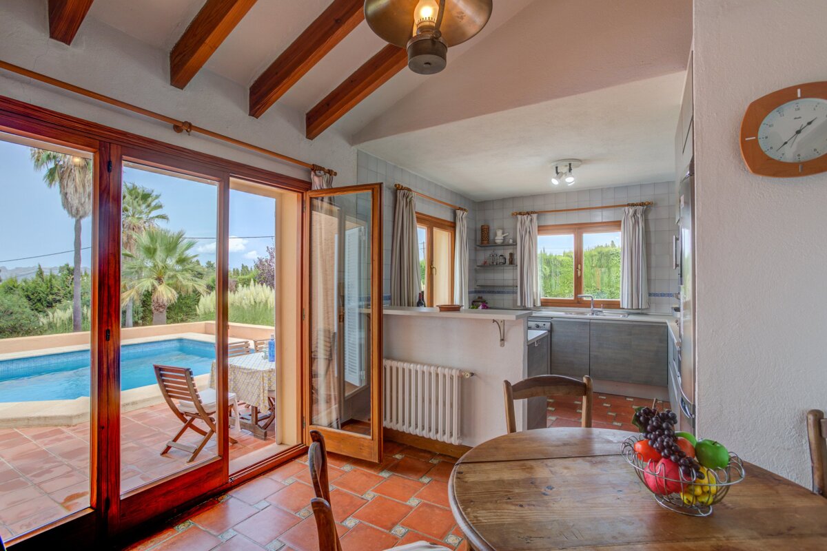 A kitchen with a bowl of fruit on the table