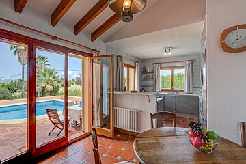 A kitchen with a bowl of fruit on the table