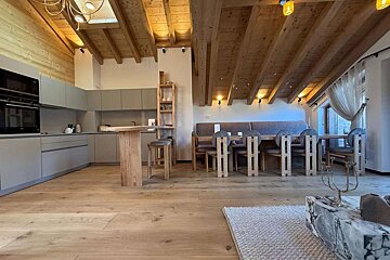 A kitchen and dining area with a wooden ceiling